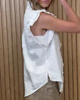 Musculosa de jean celeste sin mangas, con cuello alto fruncido, cierre frontal con botones y detalles de volados en las sisas y a lo largo de la botonera.