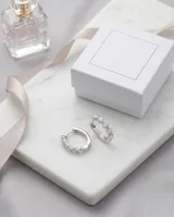 Aros tipo argolla pequeña de plata 925, decorados con una hilera de cuatro circonias brillantes engastadas.