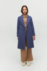 Tapado de paño azul con diseño de doble botonadura, solapas amplias y corte recto. Cuenta con bolsillos laterales discretos y forro interior.