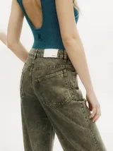 Pantalón de jean de corte recto y tiro medio, con efecto gastado. Presenta una hilera de botones en los laterales de los botapiés y bolsillos delanteros y traseros.