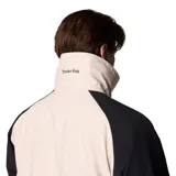 Campera técnica Columbia de la colección Iconos, con diseño impermeable y transpirable Omni-Tech. Presenta un estilo retro con bloques de color en crema y negro, cuello alto con forro interior azul, cierre frontal con solapa protectora y múltiples bolsillos. Incluye sistema de intercambio con cremallera para usar con forro reversible.