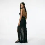 Falda larga de encaje rojo con diseño de volados laterales y transparencias, corte ajustado en la parte superior y caída fluida.