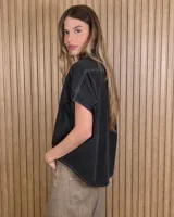 Camisa de denim liviano color azul, de mangas cortas amplias y corte oversize. Presenta cuello camisero clásico y cierre frontal con botones.