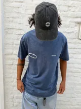 Gorro tipo gorra de béisbol color gris oscuro con efecto lavado, con un pequeño logo bordado en blanco en el frente.
