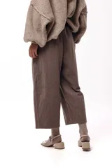 Pantalon de corte amplio y silueta relajada, color chocolate, con cintura alta, pinzas delanteras y bolsillos laterales.