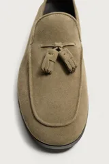 Mocasín de vestir para hombre, confeccionado en piel con acabado serraje de color tostado, con detalle de borlas en el empeine y suela de ligero tacón.