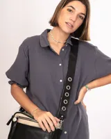 Bandolera verde con doble repartición, bolsillo frontal, correa regulable intercambiable con detalles de ojalillos.