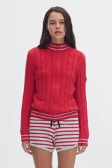 Cardigan de punto color marfil con cierre frontal completo, cuello alto y detalles de rayas en contraste en cuello, puños y ruedo. Presenta diseño de ochos verticales.