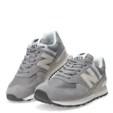 Championes New Balance modelo 574, color gris con detalles en blanco, confeccionados en gamuza y malla, con logo "N" característico en los laterales y entresuela ENCAP.