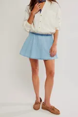 Falda pantalón de denim color celeste, de tiro medio y línea A. Cuenta con diseño de falda en la parte frontal y short incorporado en la parte trasera.