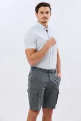Bermuda cargo color azul marino, de gabardina con bolsillos laterales con solapa en las piernas y presillas para cinturón. Incluye cinturón de lona trenzada oscura con detalles en cuero sintético y hebilla metálica.