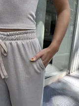 Pantalón de mujer color beige, de tela morley elastizada con líneas finas, corte holgado, cintura elástica con cordón ajustable y bolsillos funcionales.