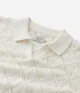 Camisa polo blanca de manga corta con cuello y tejido de punto con textura calada en forma de rombos.
