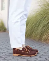 Zapato náutico de cuero gamuzado color marrón chocolate, con cordones y suela plana.