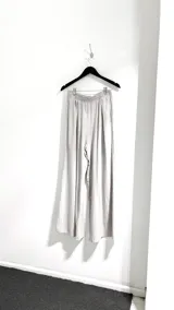 Pantalón palazzo color gris claro con cintura elástica.