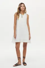 Vestido corto de lino blanco, sin mangas, con cuello redondo y diseño holgado.