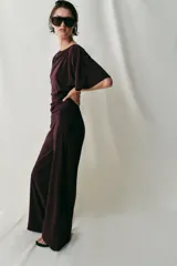 Pantalón largo color bordó, confeccionado en crepe fluido, con tiro alto, cintura elástica y diseño de pierna ancha.