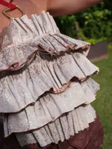 Top strapless color crema con volados estructurados en la parte delantera y elástico en la espalda.