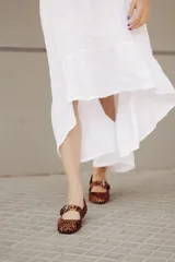 Chatitas tipo Mary Jane de charol negro con punta redondeada y tira sobre el empeine con hebilla metálica plateada.