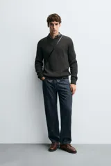 Sweater de punto en canalé color negro, de corte regular fit, cuello redondo y manga larga con terminaciones en rib.