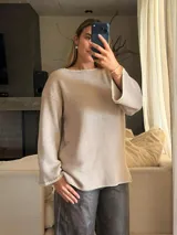 Sweater de tejido de punto jersey en color beige, con silueta oversize, cuello a la base y mangas acampanadas. Presenta terminaciones hechas a mano en crochet a contratono con sutiles detalles de lurex.