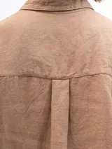 Camisa unisex de lino con mangas tres cuartos, cuello clásico, cierre frontal con botones y un bolsillo aplicado en el pecho.