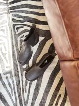 Bota Chelsea de cuero color marrón chocolate con elástico lateral negro y suela track color negro.