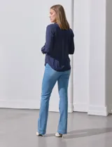 Blusa blanca de gasa marca Zac & Rachel, con cuello a la base, escote en V, abertura central con botones, bolsillo aplicado en el pecho y mangas largas regulables con presilla y botón. Tiene terminación opcional de nudo en el ruedo.