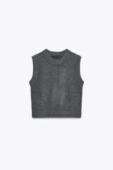 Chaleco de punto gris con cuello redondo y diseño sin mangas. Presenta terminaciones acanaladas en cuello, sisas y ruedo.