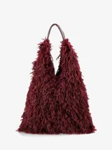 Cartera de diseño amplio y estructura flexible, confeccionada en textura de pelo sintético que aporta volumen. Cuenta con asas cortas integradas para llevar al hombro o en la mano.