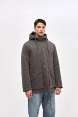 Campera tipo parka de gabardina color beige, con capucha ajustable, cierre frontal y bolsillos laterales con solapa. Presenta un diseño clásico con interior capitoneado.