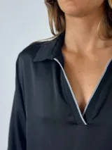 Vestido largo color borgoña de seda con cuello tipo camisa, escote en V, cierre frontal parcial con cremallera y mangas largas abullonadas.