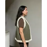 Chaleco estilo gamulán color verde militar con forro y bordes de corderito sintético blanco, diseño sin mangas.