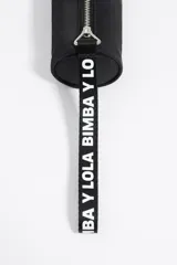 Neceser negro rectangular con cierre superior y asa de mano con logo de la marca en blanco.