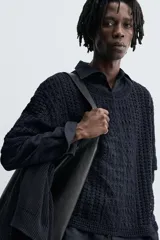 Camiseta de tejido de punto crochet con estructura abierta, color azul marino. Presenta cuello redondo y mangas cortas.