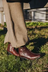 Bota de cuero vacuno color marrón con cierre lateral, taco de madera de 7cm y caña de 19cm.