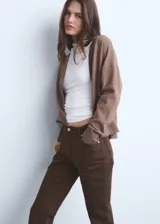 Jeans de tiro medio y corte flare con diseño crop. Presentan cinco bolsillos, cierre de cremallera con botón, trabillas en la cintura y bajo deshilachado.