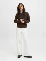 Sweater de punto color beige, con cuello polo y cierre frontal de tres botones, mangas largas con puños acanalados y diseño clásico.