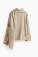 Blusa oversized color beige con estampado a rayas, confeccionada en mezcla de lino y lyocell. Cuenta con cuello fular con cintas anchas, mangas largas con puños anchos y canesú delantero y trasero.