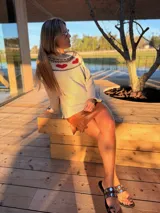 Sweater tejido color beige con cuello redondo y corazones rojos en el canesú.