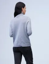 Polera de tejido fino, color rosado, con cuello alto, manga larga y detalle de tajo en los puños.