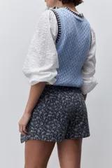 Short cruzado de tiro medio confeccionado en algodón, con diseño que imita una falda en el delantero. Presenta cierre lateral invisible y estampado floral sutil.