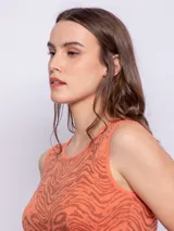 Top corto color salmón con estampado abstracto en marrón, sin mangas, con cuello redondo y terminación ondulada en el ruedo.