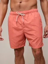 Short de baño tipo volley, color salmón, con cintura elástica y cordón ajustable en contraste. Confeccionado en tejido de poliamida con acabado lavado.