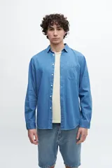 Camisa de manga larga celeste de denim con bolsillo en el pecho.
