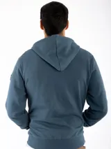 Campera canguro Kevingston de jersey frisado invisible de algodón, en color azul. Presenta cierre frontal completo, capucha con cordón ajustable y bolsillos delanteros amplios tipo canguro.