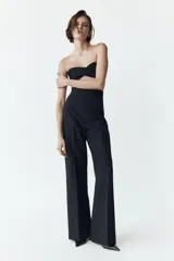 Pantalón de vestir color crudo, de tiro alto y pierna acampanada.