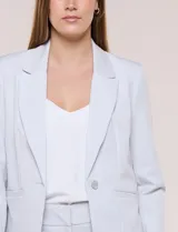Blazer de sastre entallado color gris claro, con solapa de muesca clásica, cierre frontal de un solo botón y bolsillos frontales de vivo horizontales.