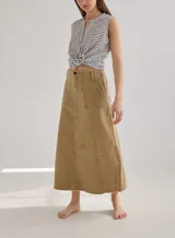 Falda midi color beige, de corte evasé, con bolsillos delanteros y ruedo desflecado.