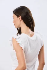 Remera de algodón azul melange con escote redondo y mangas cortas adornadas con doble volado de broderie en los hombros.